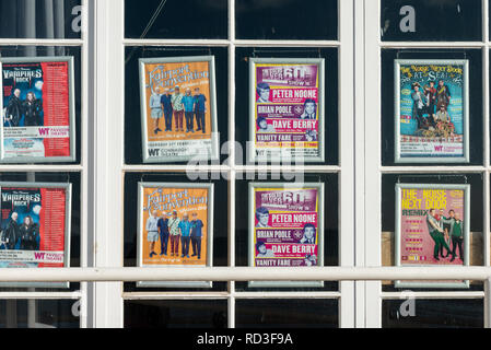 Theatre posters on display in the window of the Connaught Theatre in Worthing, Sussex, England. Stock Photo