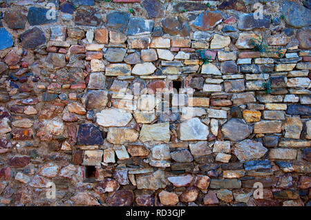 Old stone wall with two small windows, Malaga, Spain Stock Photo