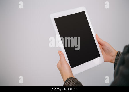 cropped view on businesswoman using digital tablet with blank screen isolated on grey Stock Photo