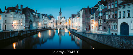 Beautiful panoramic view of famous Spiegelrei canal with famous Poortersloge and Jan van Eyck square in the background illuminated during blue hour at Stock Photo