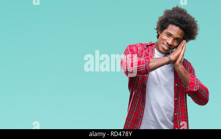 Afro american man over isolated background sleeping tired dreaming and posing with hands together while smiling with closed eyes. Stock Photo