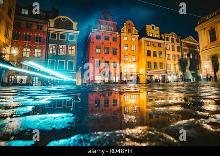 Classic view of colorful houses at famous Stortorget town square in Stockholm's historic Gamla Stan (Old Town) reflecting in a puddle at night Stock Photo