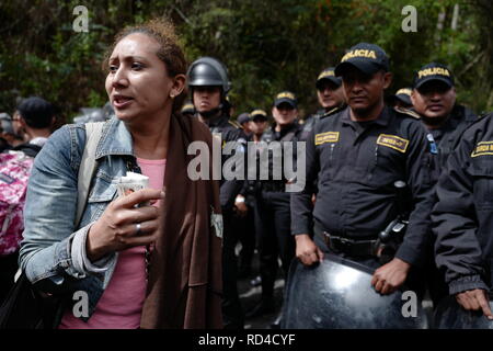 Aguas Calientes, Guatemala. 16th Jan, 2019. A migrant with her identity card in her hand stands in front of a number of police officers at the Aguas Calientes border crossing between Honduras and Guatemala. A so-called migrant caravan had left the Honduran city of San Pedro Sula to the north. According to the government of Honduras, 700 people entered Guatemala with and without the necessary papers. The group plans to immigrate to the USA. Credit: Morena Perez Joachin/dpa/Alamy Live News Stock Photo