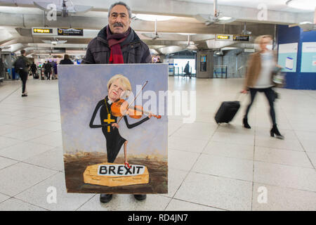 London, UK. 16th January, 2019. London-based satirical artist Kaya Mar with his work on Theresa May and Brexit in Westminster underground Station. Credit: Guy Bell/Alamy Live News