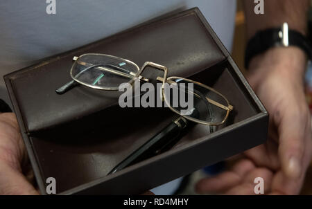 Berlin, Germany. 17th Jan, 2019. The reading glasses and a pen by Winnetou actor Pierre Brice are held by a man in an auction house. On 26 January, the Berlin auction house will auction off numerous pieces from the estate of the legendary Karl May actor. Credit: Paul Zinken/dpa/Alamy Live News Stock Photo