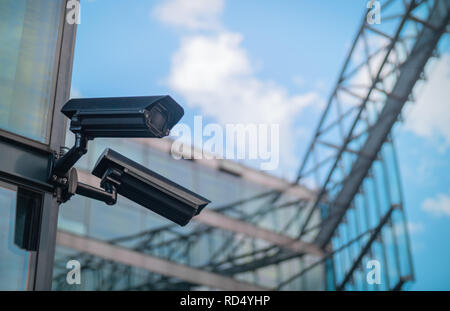 Pair of surveillance cameras on the side of a modern building Stock Photo