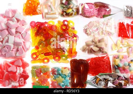 Clear plastic bags with a variety of fruit gums, marshmallows, candies, lollipops, cookies and gummy bears Stock Photo