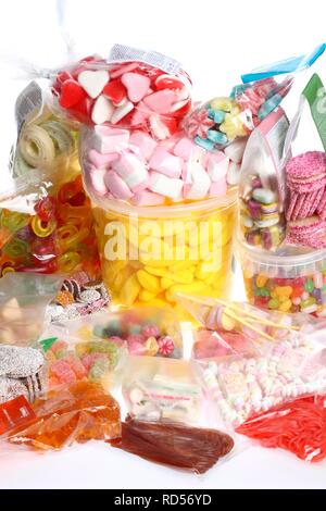 Clear plastic bags with a variety of fruit gums, marshmallows, candies, lollipops, cookies and gummy bears Stock Photo