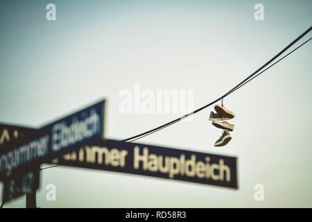 Shoes hang on a power supply line in Hamburg, Germany, Schuhe hängen an einer Stromleitung in Hamburg, Deutschland Stock Photo