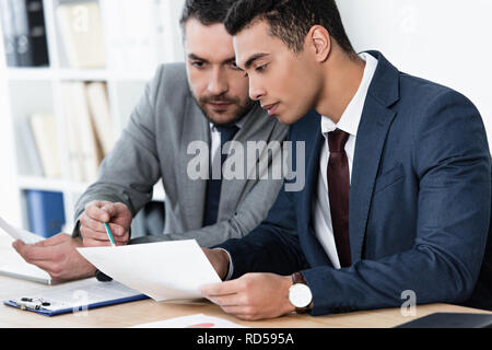 two focused businessmen working with papers in office Stock Photo