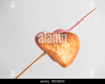 roasted heart form marshmallows on a skewer on white background. Stock Photo