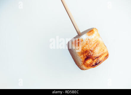 roasted marshmallows on a skewer on white background. Stock Photo