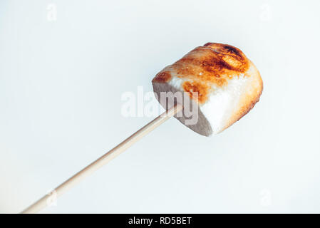 roasted marshmallows on a skewer on white background. Stock Photo