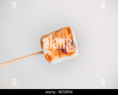 roasted marshmallows on a skewer on white background. Stock Photo