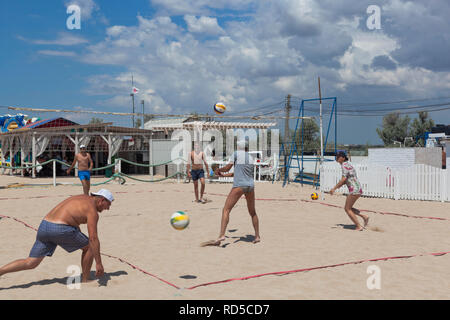 Evpatoria, Crimea, Russia - July 4, 2018: Young people play volleyball on Rodnichok beach in the resort town of Evpatoria, Crimea Stock Photo