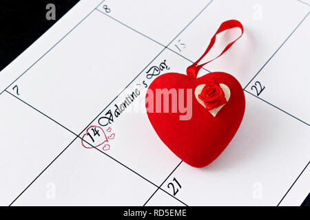 Calendar page with red hearts on February 14, Valentine's Day on a black background. Valentines day greeting card. Stock Photo