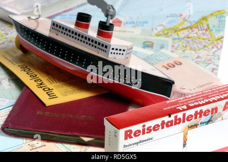 First-aid kit, vaccination card, miniature ship Stock Photo