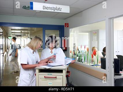 Nurses discussing patient care procedures, preparing documents for the patients of the ward, hospital Stock Photo