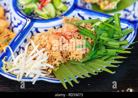 Thailand street food: Mi krop, Traditional Thai Crispy Noodle Dish made with rice noodles and sweet flavored sauce, served on banana leaf with vegetab Stock Photo