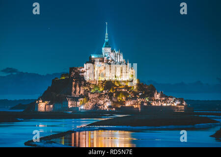 Classic view of famous Le Mont Saint-Michel tidal island in beautiful twilight during blue hour at dusk, Normandy, northern France