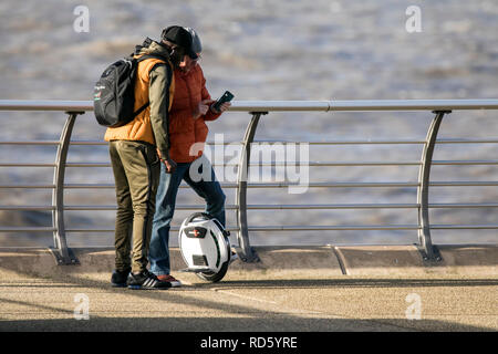 A man rides his self balancing unicycle gyro scooter along the promenade in Blackpool, Lancashire, UK Stock Photo