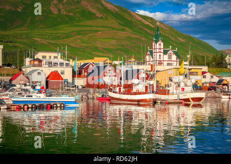 Scenic view of the historic town of Husavik in beautiful golden evening light at sunset with blue sky and clouds, north coast of Iceland Stock Photo