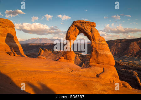 Classic postcard view of famous Delicate Arch, symbol of Utah and a popular scenic tourist attraction, in beautiful golden evening light at sunset Stock Photo