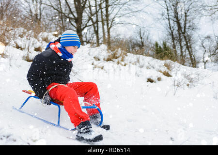 for a sledge down the boy in red pants is very happy 2019 Stock Photo