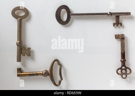 Flat lay of a set of old rusty keys on a white background Stock Photo