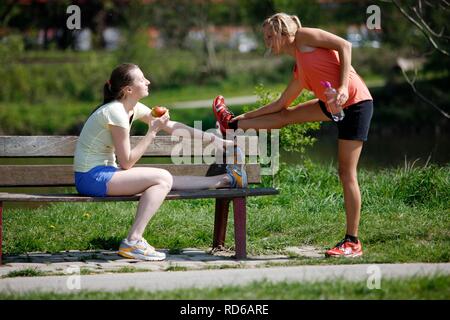 Recreational runners, young women, 25 - 30 years, eating and drinking after jogging Stock Photo