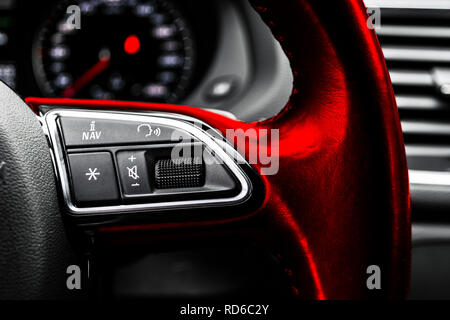 Modern car interior. Red Steering wheel with media phone control buttons, navigation multimedia system background. Car interior details. Car detailing Stock Photo