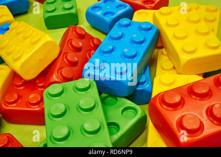 Oversized children's colorful plastic building blocks scattered on the floor. Stock Photo