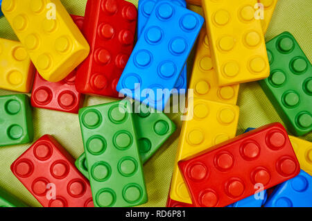 Oversized children's colorful plastic building blocks scattered on the floor. Stock Photo