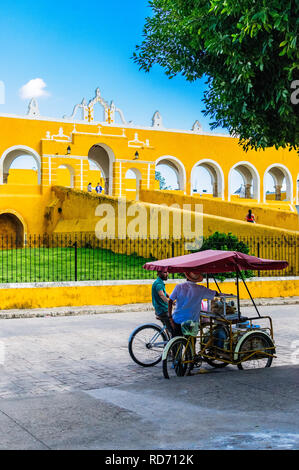 IZAMAL, YUCATAN / MEXICO - NOVEMBER 10 2018: Street seller on his tricycle in front of the monastery of Izamal, called the yellow city Stock Photo