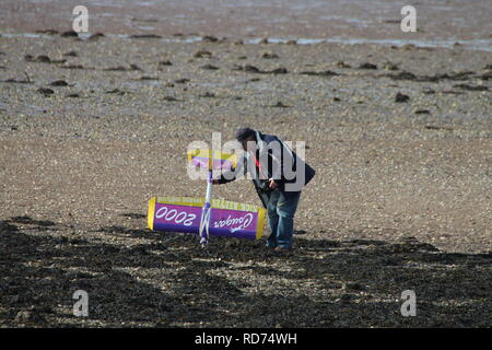 A radio-controlled model aircraft flyer attends to his aircraft on the beach at Fairlie in Ayrshire. Stock Photo