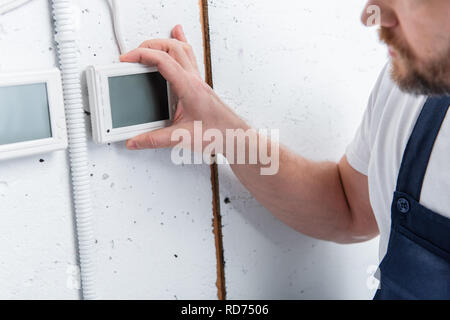 partial view of adult electrician checking electrical panel Stock Photo