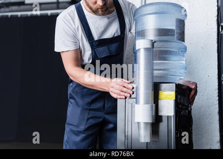 partial view of handyman checking broken water cooler Stock Photo