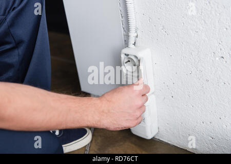 partial view of male electrician checking plug socket Stock Photo