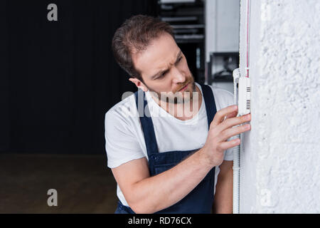concentrated bearded handyman checking electrical panel Stock Photo