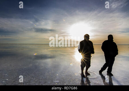 People reflections at Uyuni saltflats. One of the most amazing things that a photographer can see. Sunrise over an infinite horizon in Salar de Uyuni Stock Photo