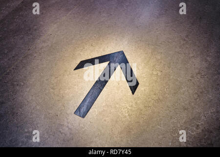Arrow mark on floor of a large facility helps shopping customers navigate quicker. Stock Photo