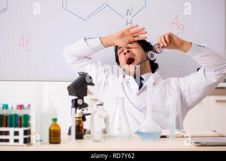 Young funny chemist in front of white board Stock Photo