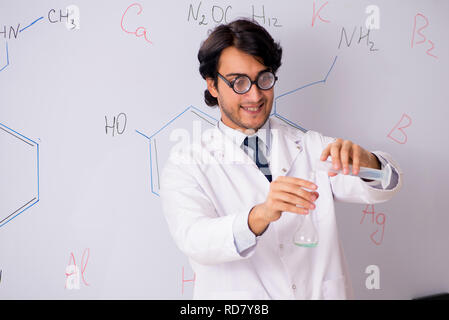 Young funny chemist in front of white board Stock Photo