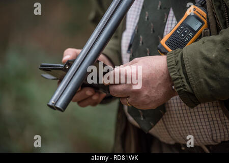 man with shotgun, radio  and mobile phone Stock Photo