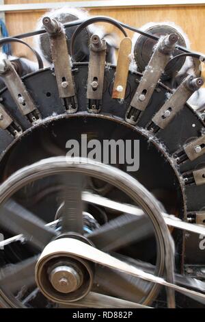 Wool thread being spun from raw wool product , part of process to create woll knitwear products in Woolen mill Stock Photo