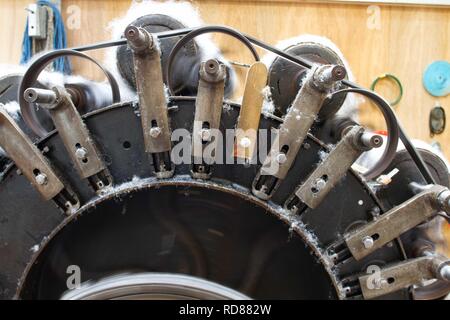 Wool thread being spun from raw wool product , part of process to create woll knitwear products in Woolen mill Stock Photo