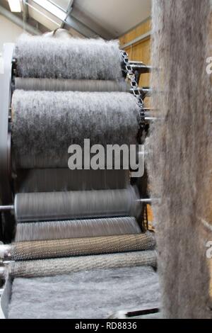 Wool thread being spun from raw wool product , part of process to create woll knitwear products in Woolen mill Stock Photo