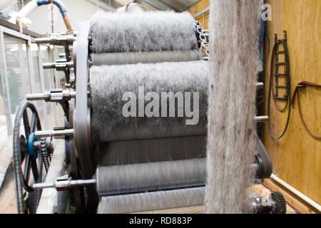 Wool thread being spun from raw wool product , part of process to create woll knitwear products in Woolen mill Stock Photo