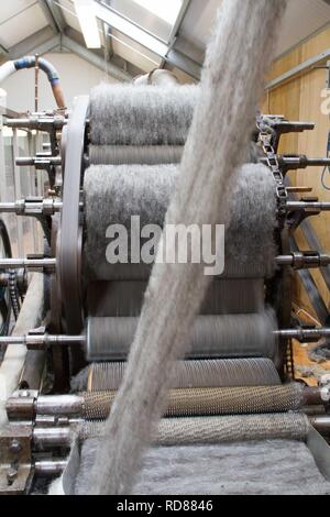 Wool thread being spun from raw wool product , part of process to create woll knitwear products in Woolen mill Stock Photo