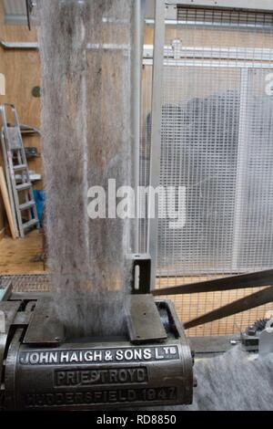 Wool thread being spun from raw wool product , part of process to create woll knitwear products in Woolen mill Stock Photo